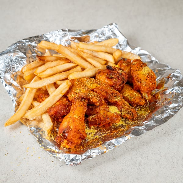 Jaws Hot Chicken & Seafood's hot wings and fries, served in aluminum foil.