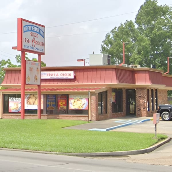 Exterior of Jaws Hot Chicken & Seafood, a brick building with a red roof and a large sign.