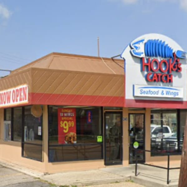 Exterior of Hook's Catch restaurant with a "Now Open" sign and a "Seafood & Wings" banner.
