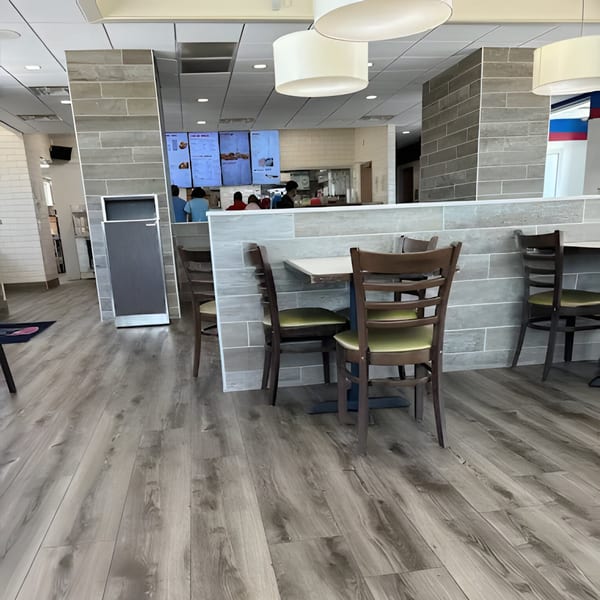 Interior of Jaws Hot Chicken & Seafood, featuring tables, chairs, and a counter with menu screens.